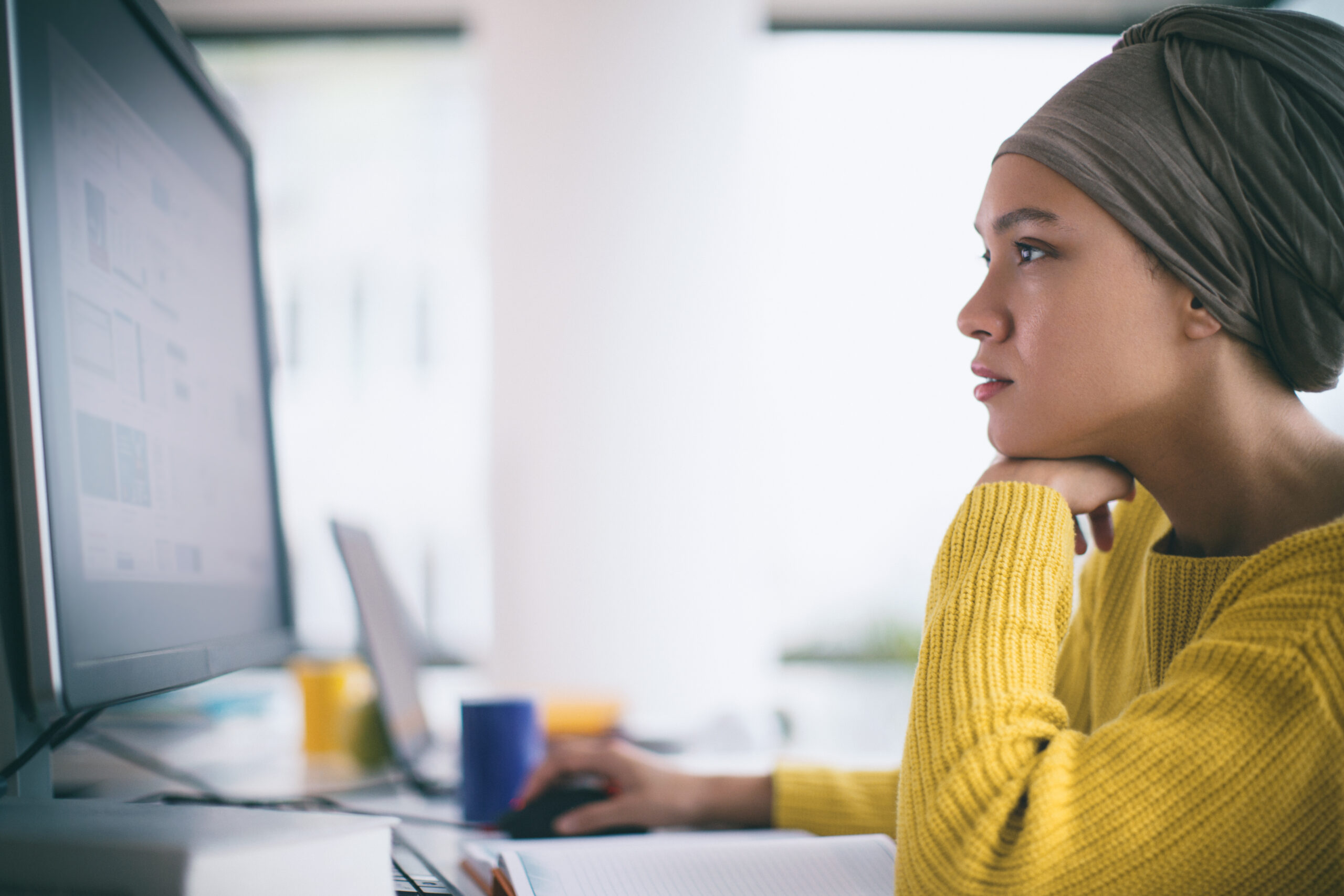 Woman in office on desktop computer.