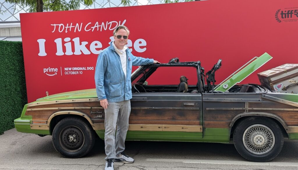 Image of marketing copywriter Garry Murdock standing in front of the burned out replica of the vehicle Steve Martin and John Candy drove in Planes, Trains & Automobiles.