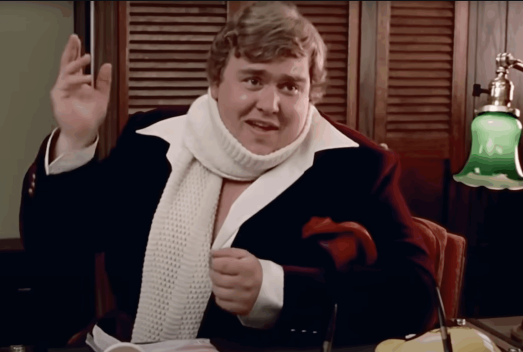 Image of John Candy in red jacket and white scarf from the movie Splash.