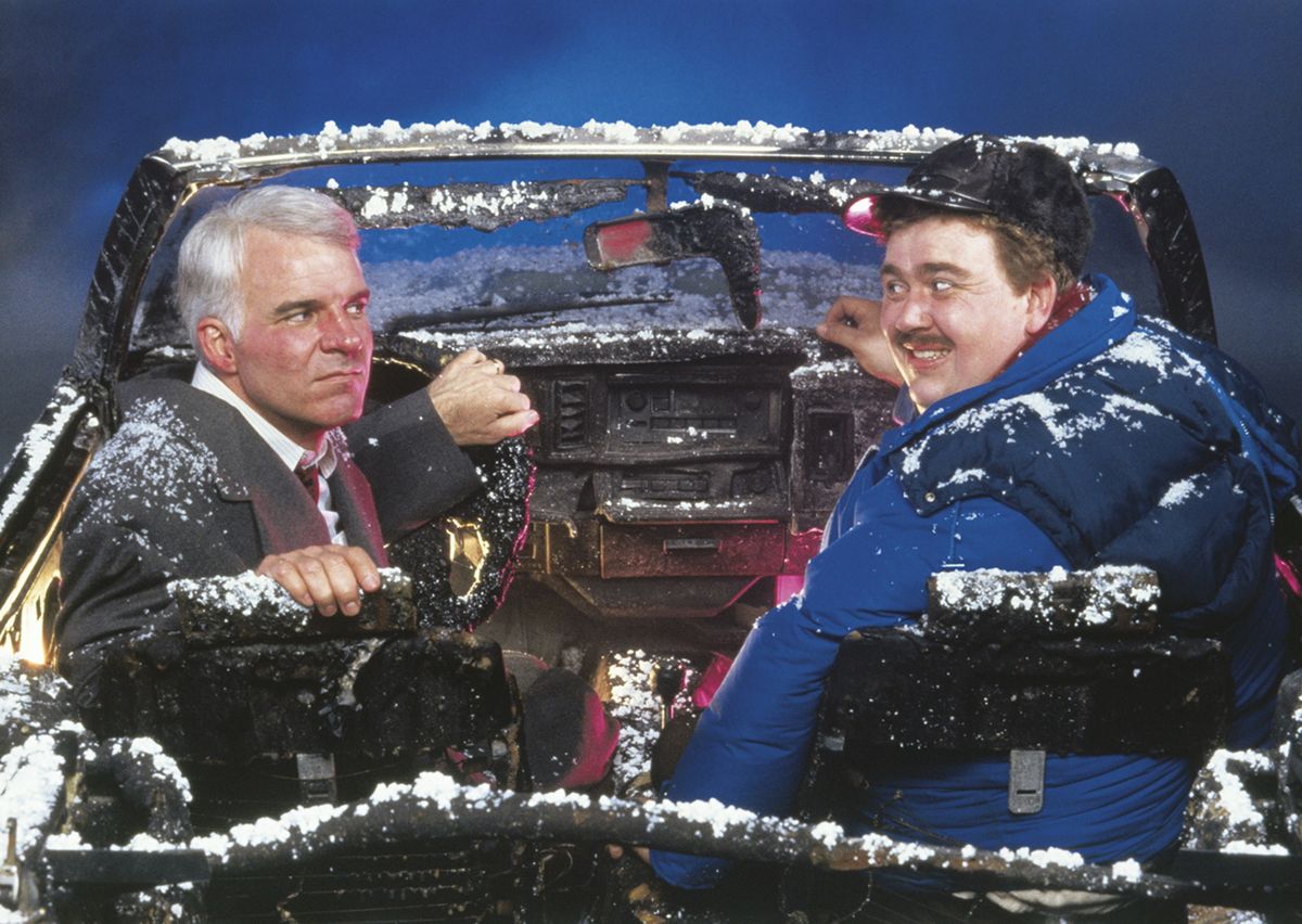 Image from the movie Planes, Trains & Automobiles. Steve Martin and John Candy are sitting in a burned out car, hoping to make it home for Thanksgiving.