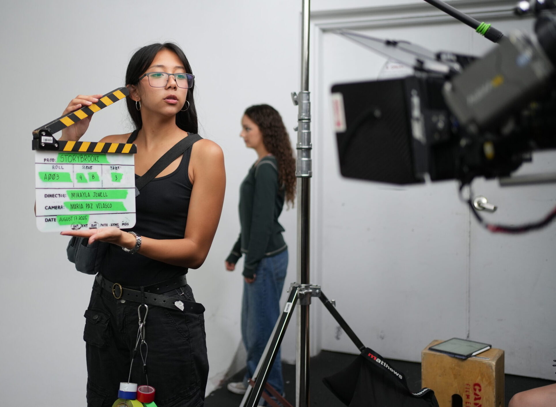 Shot of student holding clapboard in front of camera in one of Toronto Film School's studios. 